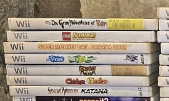 Five stacked Wii game cases: The Grim Adventures of Billy & Mandy, LEGO Batman 2, Super Monkey Ball Banana Blitz, Chicken Blaster, and Samurai Warriors: Katana.